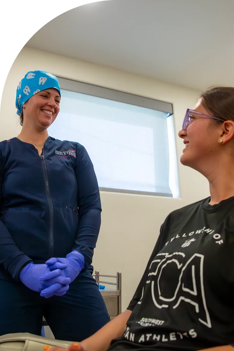 Dental assistant smiling while talking with a patient